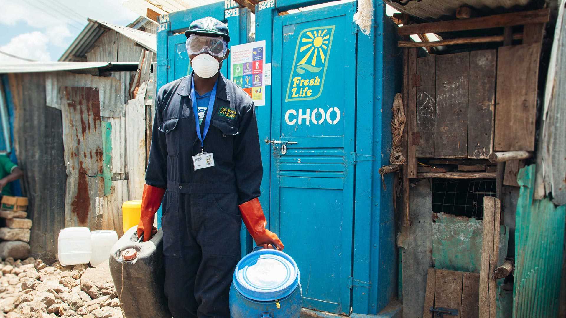 A man carrying sealed buckets to collect waste from slums